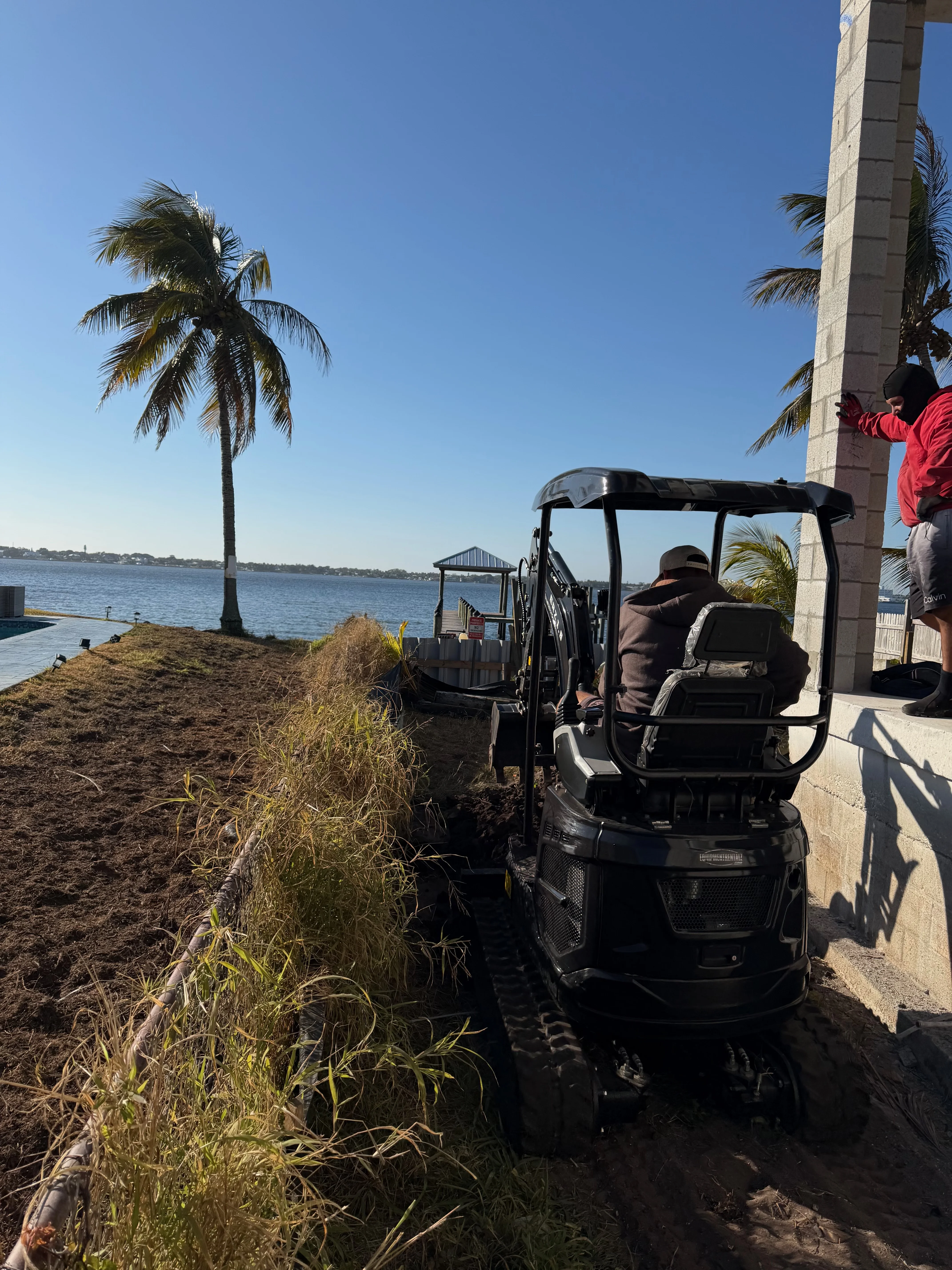 Mini excavator waterfront landscaping job Palm Beach County FL